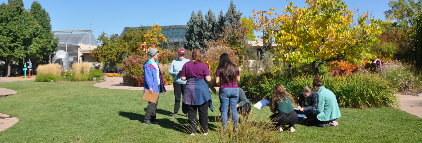 Group of students stand in grassy area at the Gardens of Spring Creek.