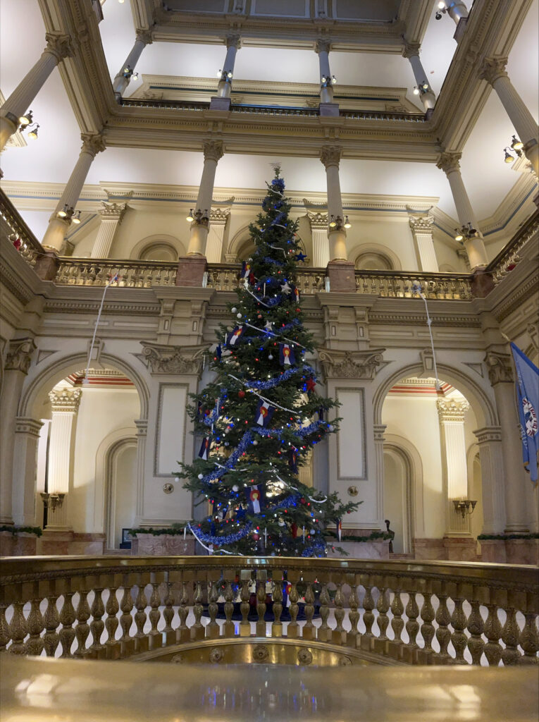 Holiday tree decorated with lights and flags inside the Colorado Capitol building