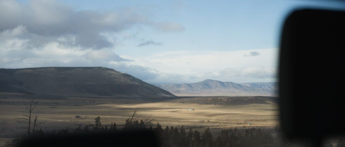 Looking through truck window at mountain range and plains